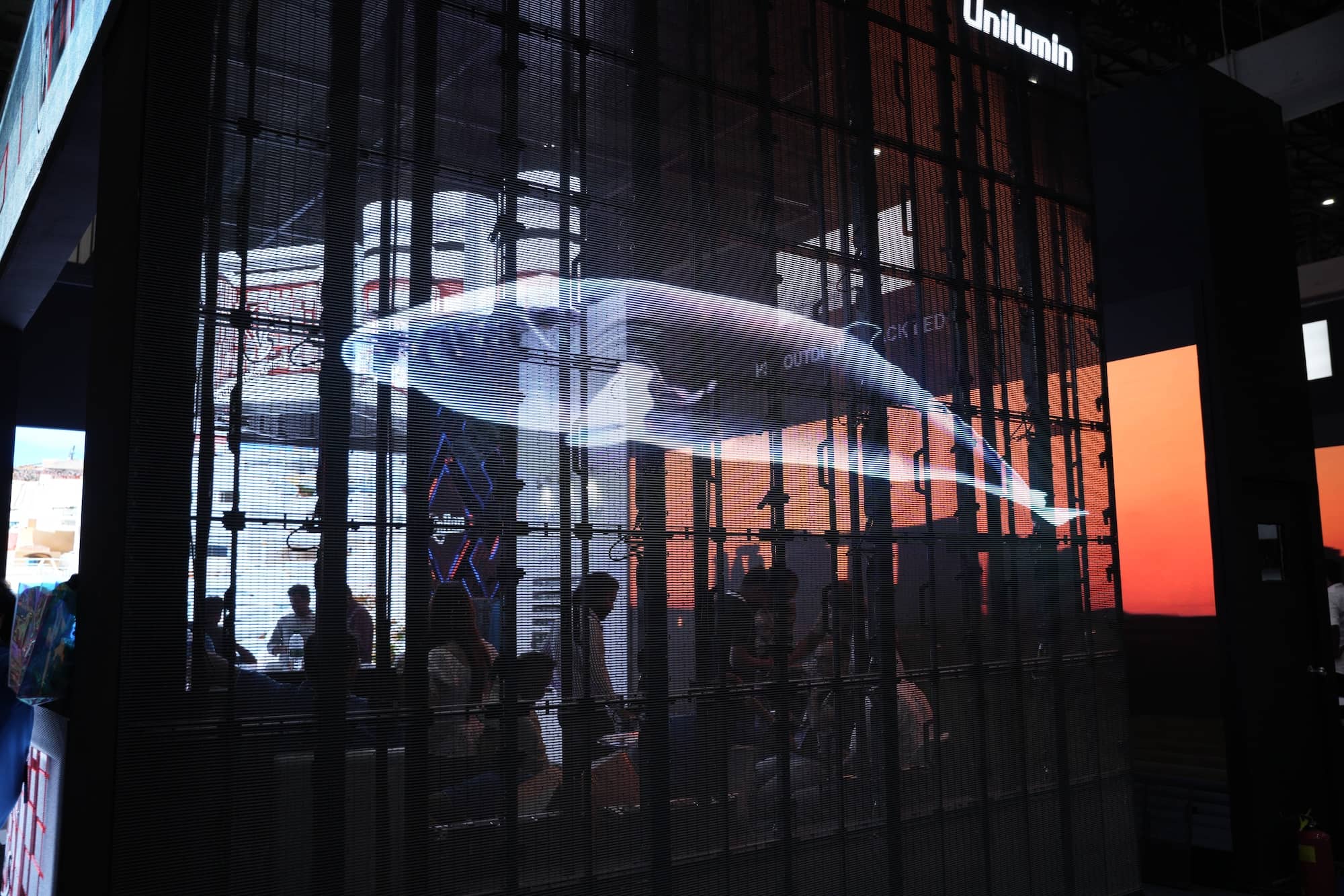 Digital whale projection on a transparent display with people viewing the installation.