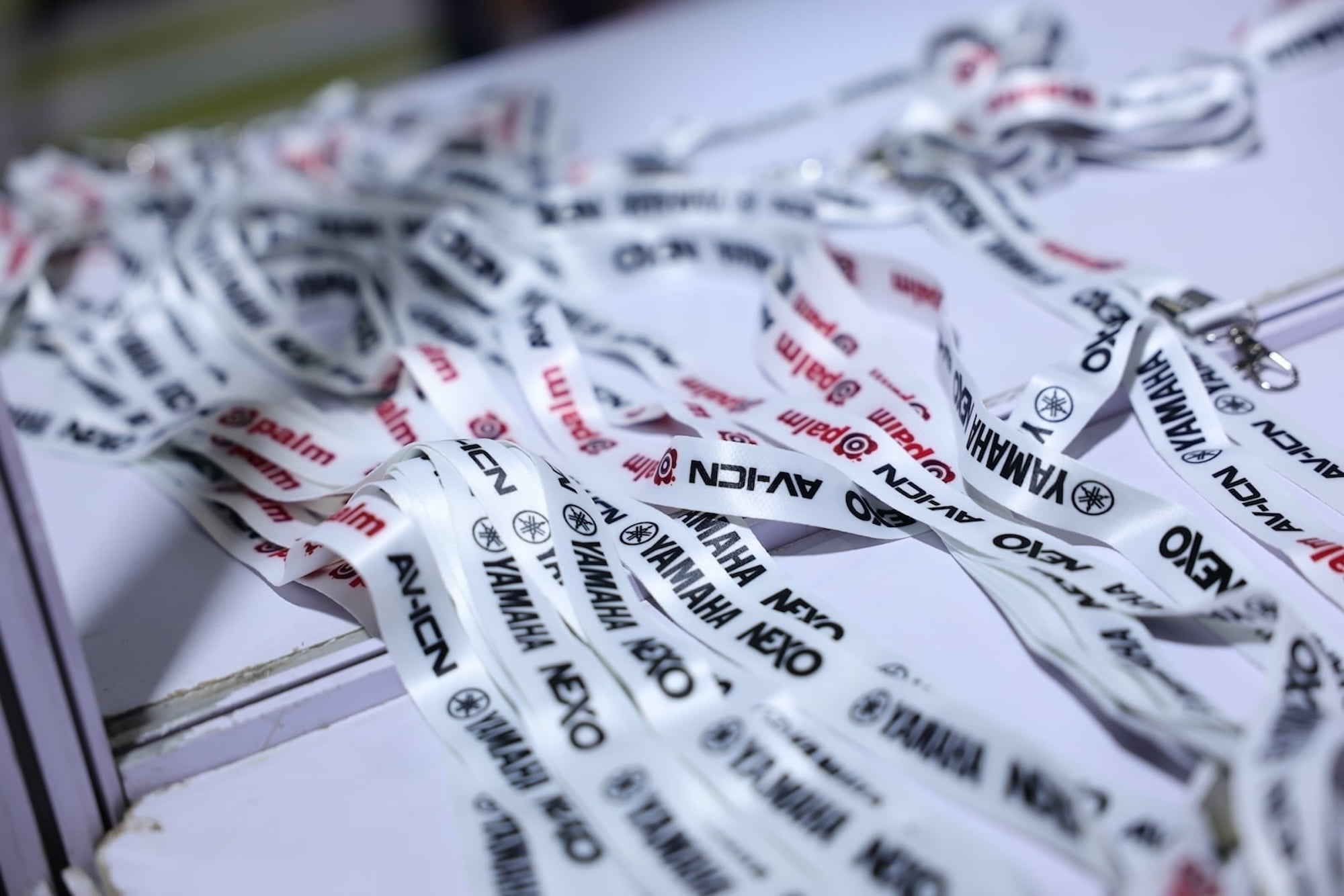 A pile of AV-ICN event lanyards branded with sponsor Yamaha