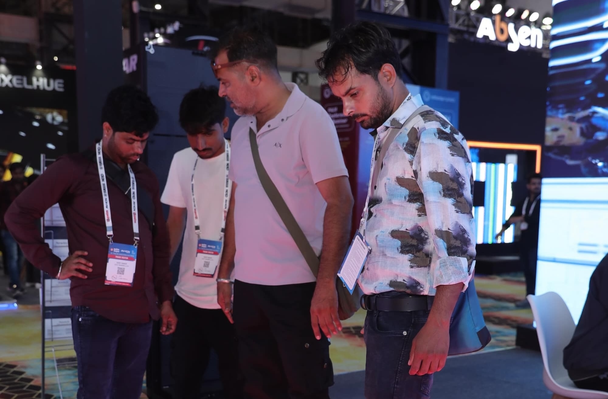 People examining an interactive LED floor display at a technology exhibition.