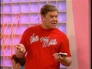 Crunch Grabowski in a red shirt that reads "The Max" as he hold a notebook.