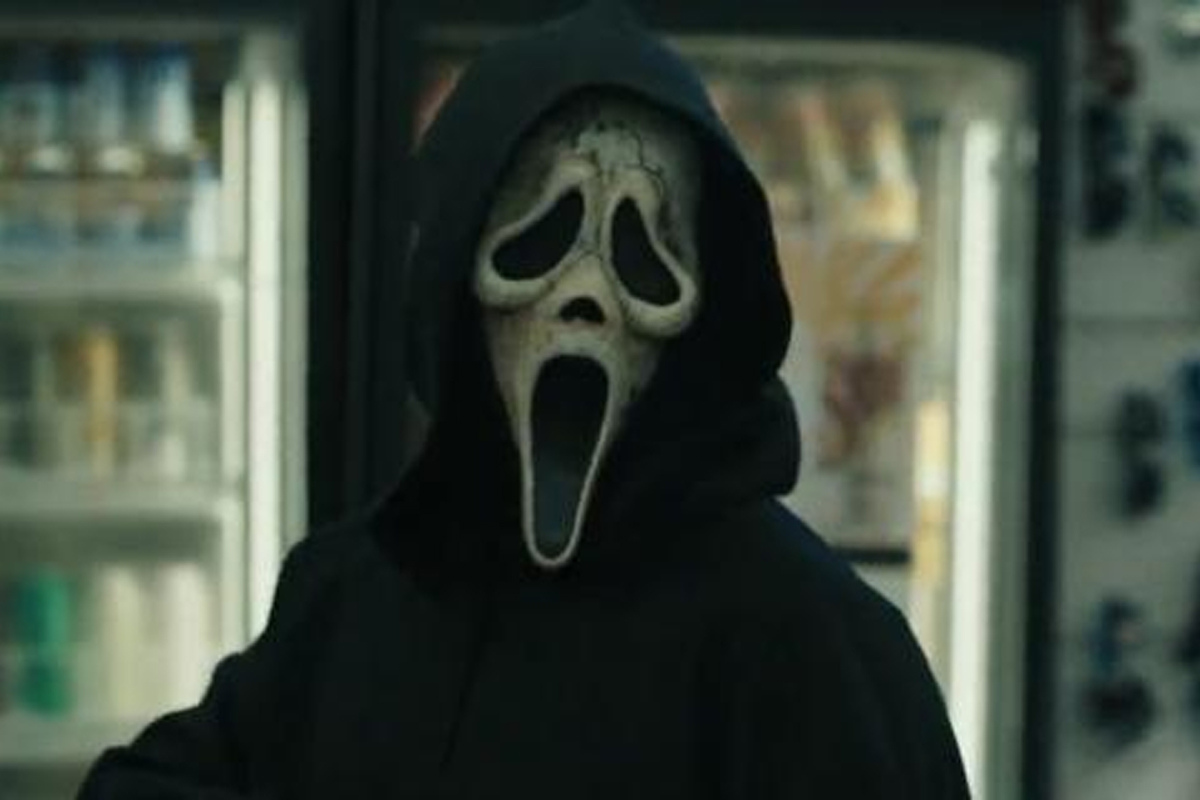 Ghostface from Scream 6 looks at the camera with drink machines in a convenience store behind him