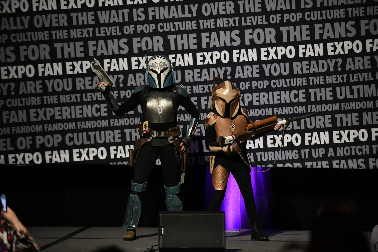 Cosplay Red Carpet Walk on Exhibition: Bo Katan and Mando walk the carpet. Blasters held high.