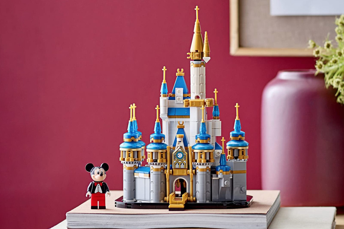 Mini Cinderella Castle in the blue, white, gray and gold coloring. There is a Mickey Mouse Figurine in a tux and red pants.