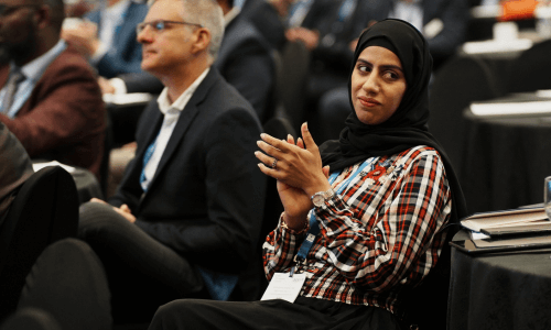 young woman wearing hijab sitting in the audience