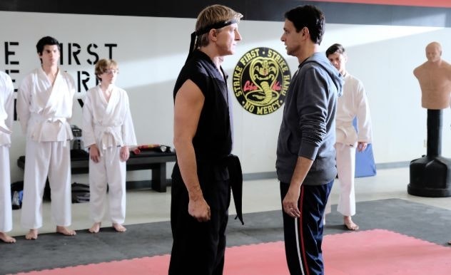 Two karate masters at a dojo face off against each other while their students look on