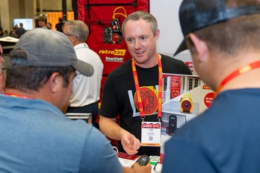 Attendees and exhibitors discussing a product on the show floor