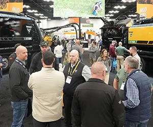 Group of attendees networking near a truck on the expo floor