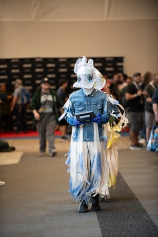 Creatures of Meow Wolf - with headpieces made of lace and beads, and suits make of denim and fringe, the creatures walk the line and interact with fans with their memory machine