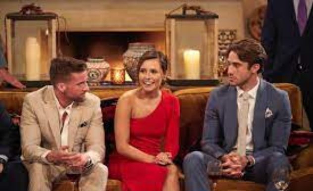 three people dressed nicely sit on a couch and engage in conversation