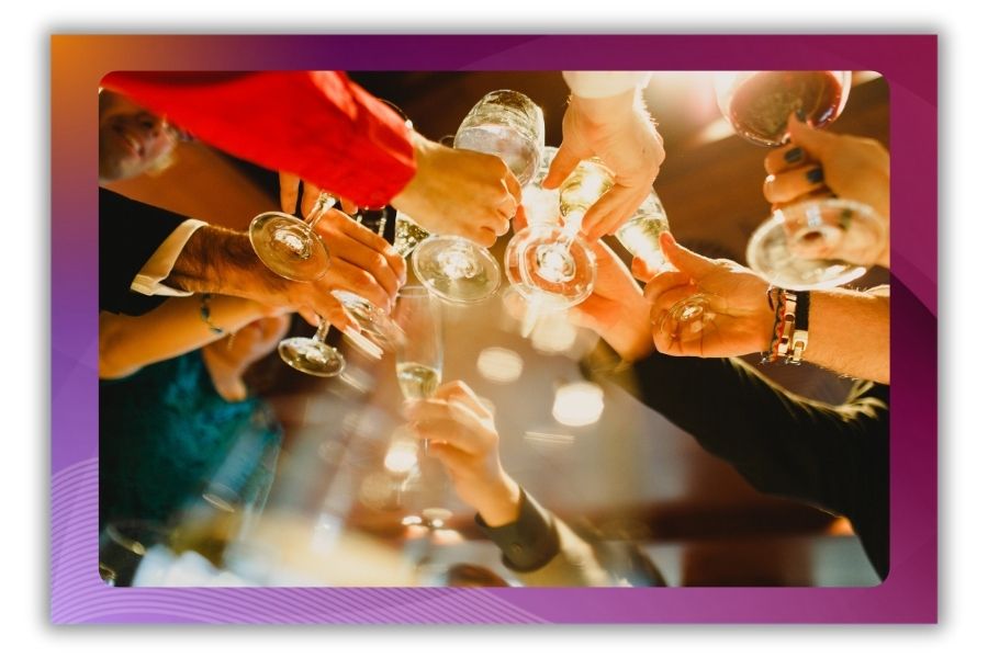 A photo of people toasting with wine glasses