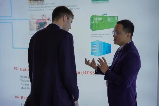 Attendees reviewing a presentation board at an exhibition booth.