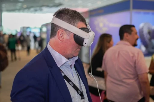 Attendee speaking with others in the event exhibition area.