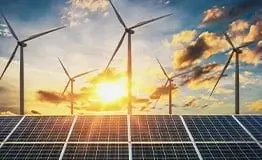 Parque de energia renovável combinando painéis solares fotovoltaicos em primeiro plano e turbinas eólicas ao fundo sob o pôr do sol, simbolizando a transição energética.