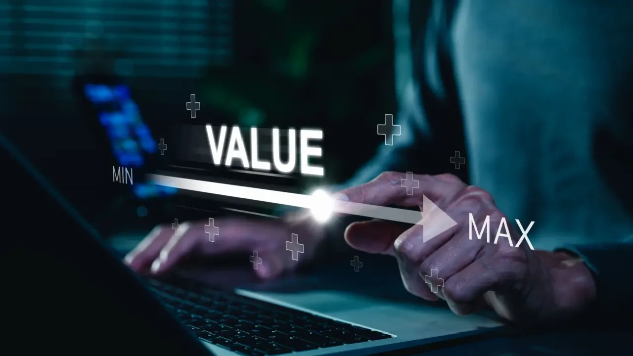 Interface digital exibindo uma barra de progresso com os termos "MIN", "MAX" e a palavra "VALUE" em destaque. Uma mão interage com o seletor, simbolizando a maximização de valor e eficiência operacional, temas centrais para C-Levels na Hospitalar 2026.