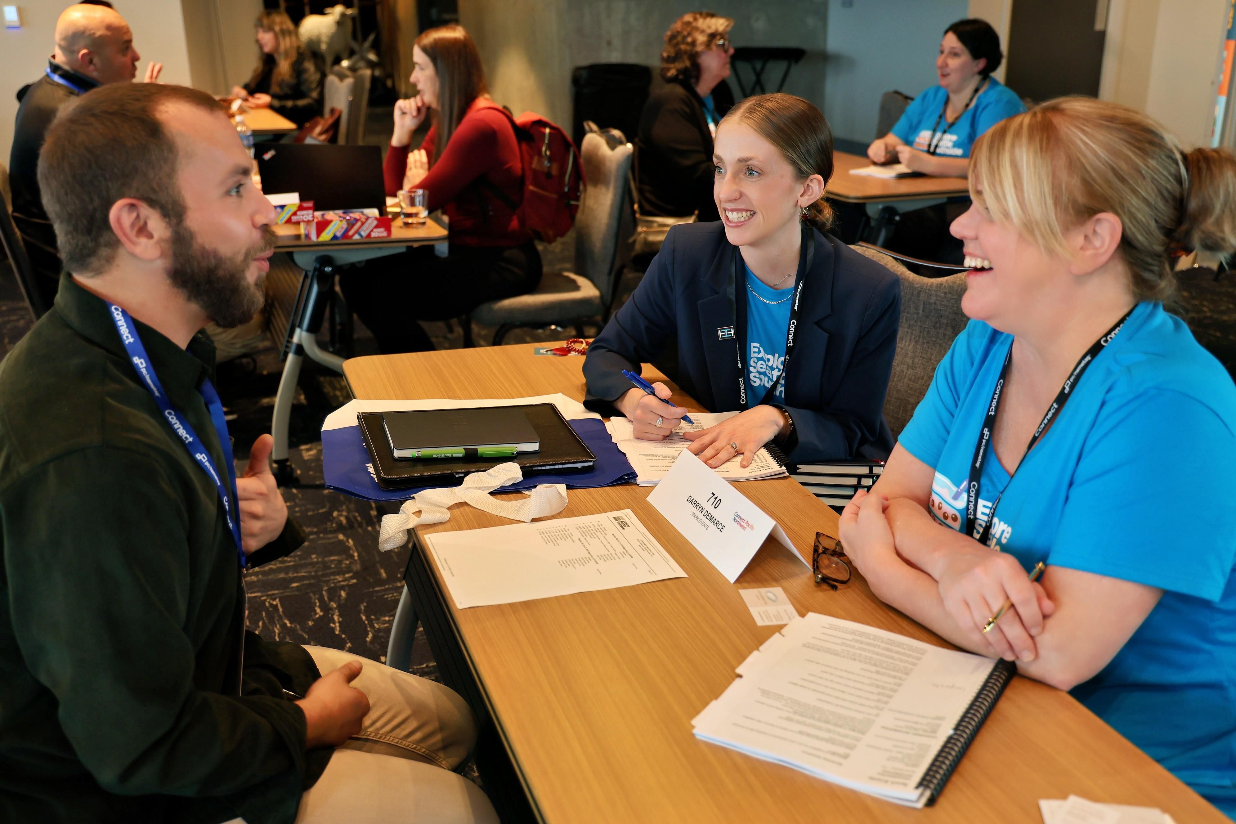 A man and two women smiling during marketplace appointments.
