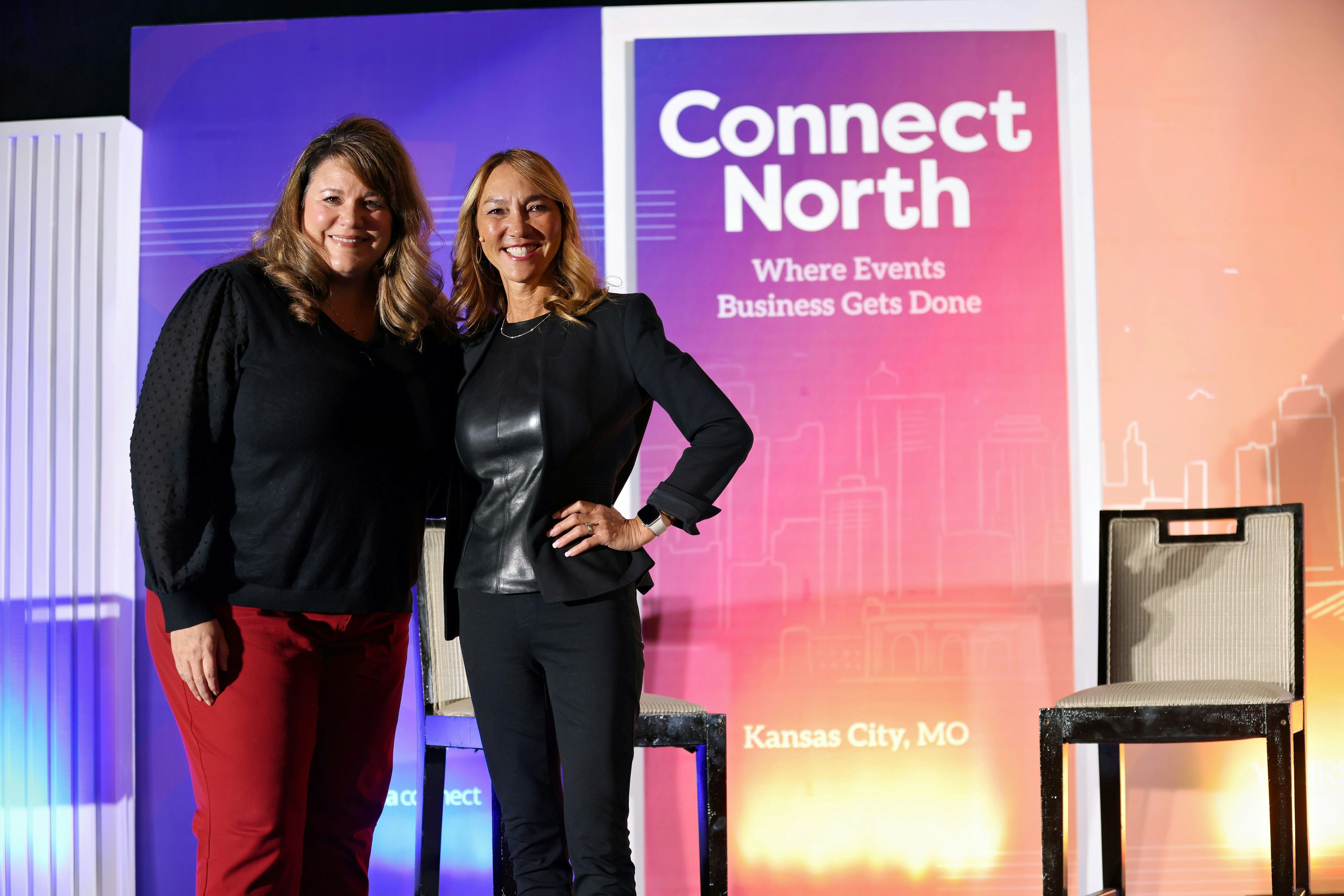 Two women on stage smiling and posing after their education session at Connect North.