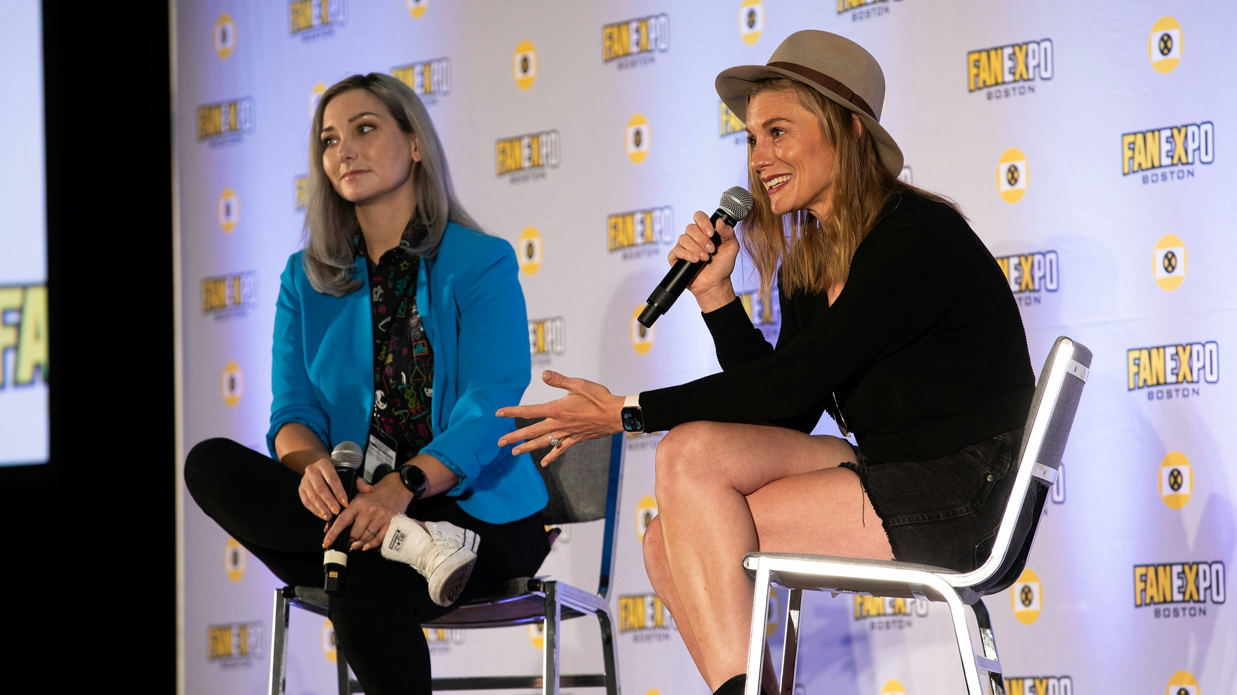 Katee Sackhoff smiles as she speaks into a microphone on stage