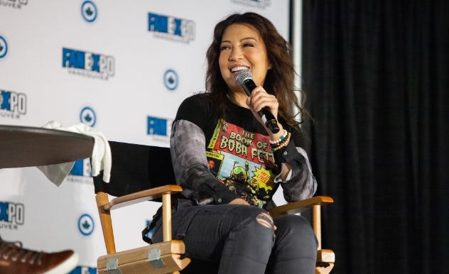 Ming-Na Wen smiles in a Book of Boba Fett T-Shirt as she answers a question on stage