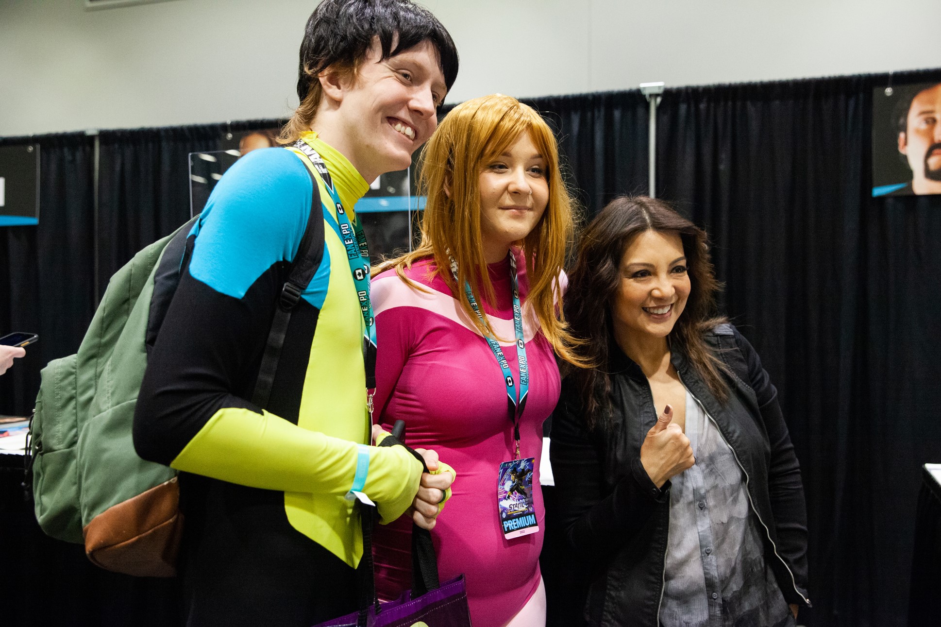 Actress Ming-Na Wen posing with two fans dressed up as characters from Invincible.