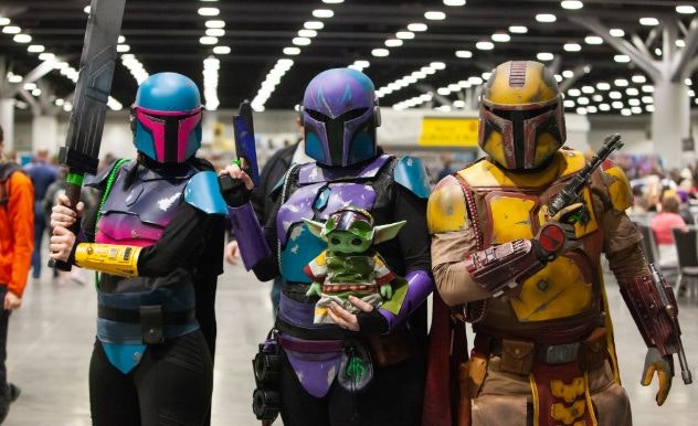 A group of customized Mandalorian cosplayers pose with a Grogu dressed as Boba Fett