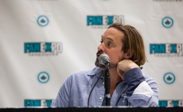 Will Friedle looks serious as he answers a question on stage
