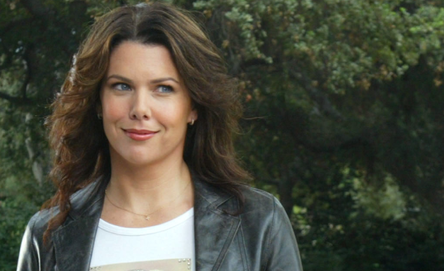 Lorelai Gilmore from Gilmore Girls smiling at someone off screen wearing a leather jacket