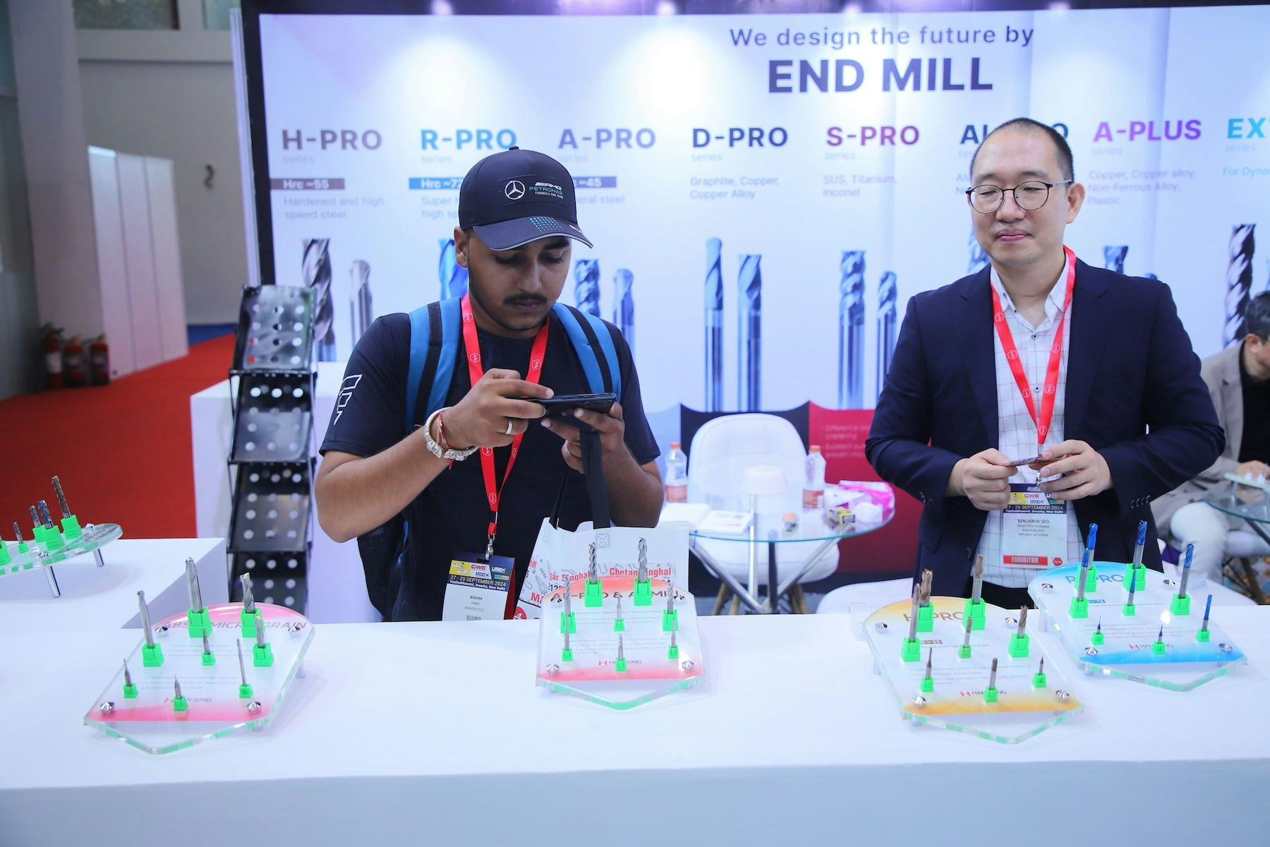 Visitor and exhibitor at end mill cutting tools booth with carbide samples on display at Tools & Equipment Expo