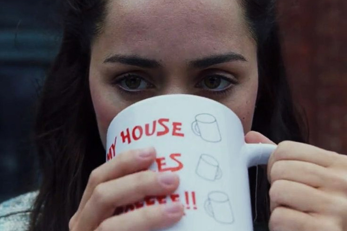 Marta holding a mug that says My House