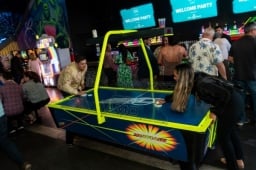 2 people playing against each other in air hockey at the WasteExpo Welcome Reception