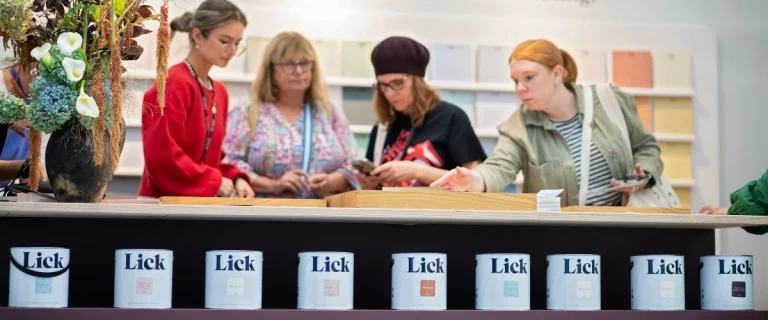 four women looking at paints displayed at exhibition standNDS
