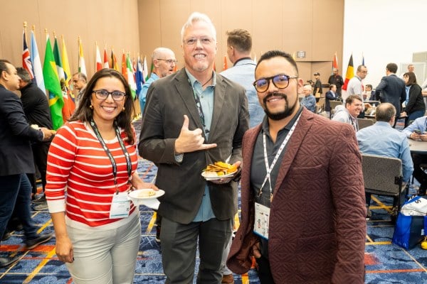 3 attendees posing for a photo at the international reception
