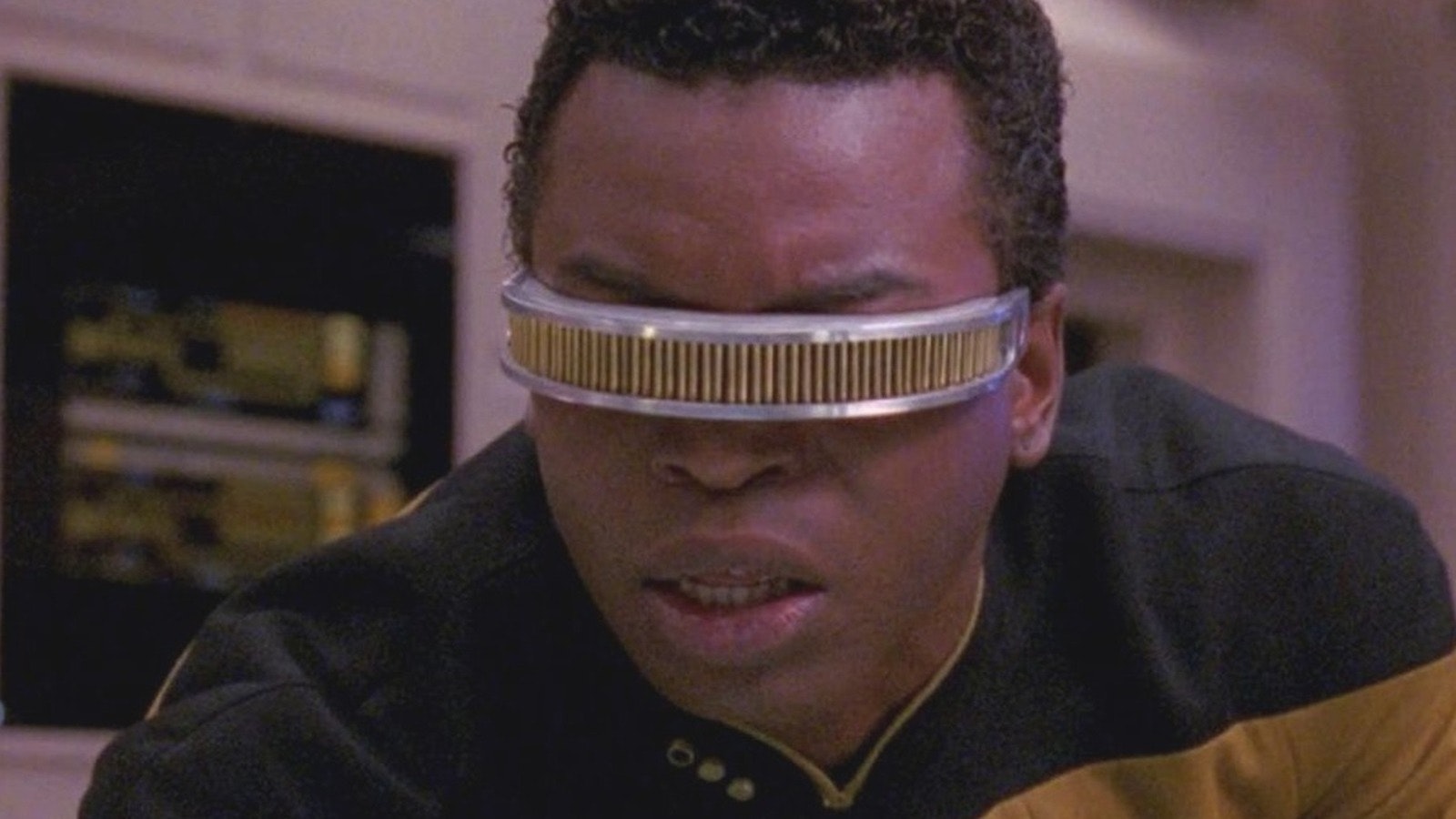 La Forge feels around on the motherboard, his face painted in horror with mouth agape and furrowed brows. his eye covering stars straight at the screen