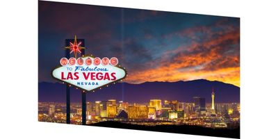 A photo of the Welcome to Las Vegas sign with the Las Vegas Skyline in the background