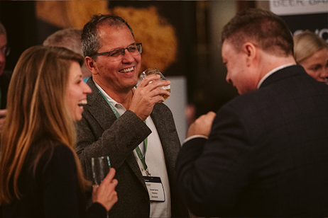 2 men and 1 woman laughing at beer bar reception