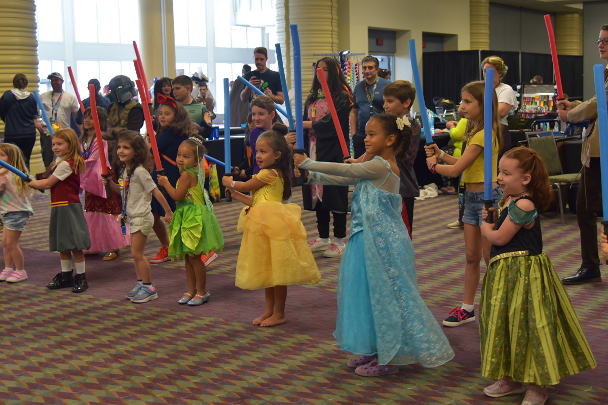 A group of young Disney Princess' prepare for a lightsaber battle