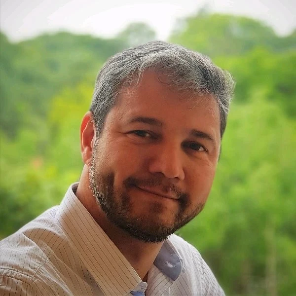 Luiz Gustavo Kiatake, palestrante do Healthcare Innovation Show, homem sorrindo de barba e cabelo grisalho.