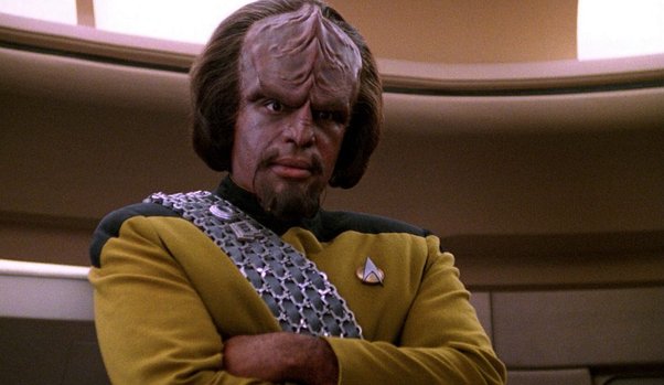 Worf crosses his arms and stares in disappointment at one of this shipmates (off screen)