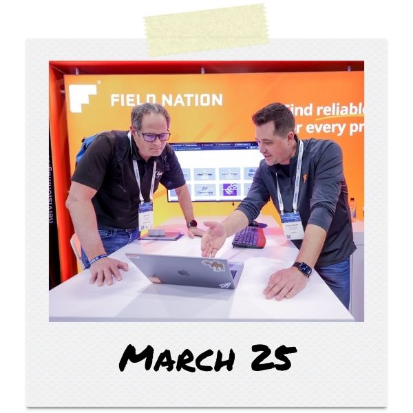 A photo of two men looking at a laptop at a trade show booth. Text below the photo says "March 25"