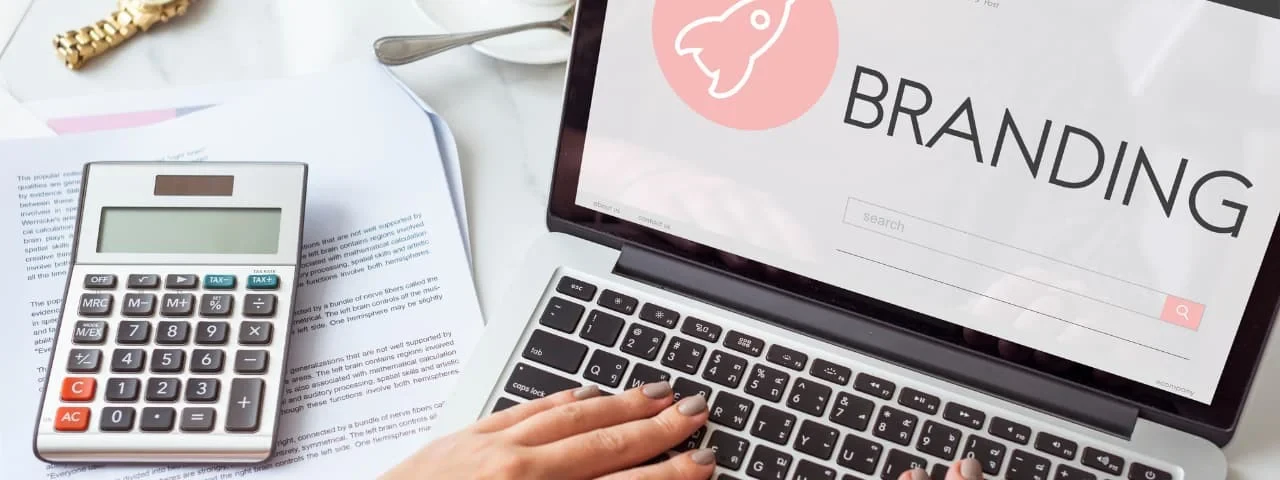 Yakında ofis kağıtlarının üzerinde duran bir hesap makinesinin bulunduğu, marka bilinci oluşturma başlangıç ekranını gösteren bir dizüstü bilgisayar.