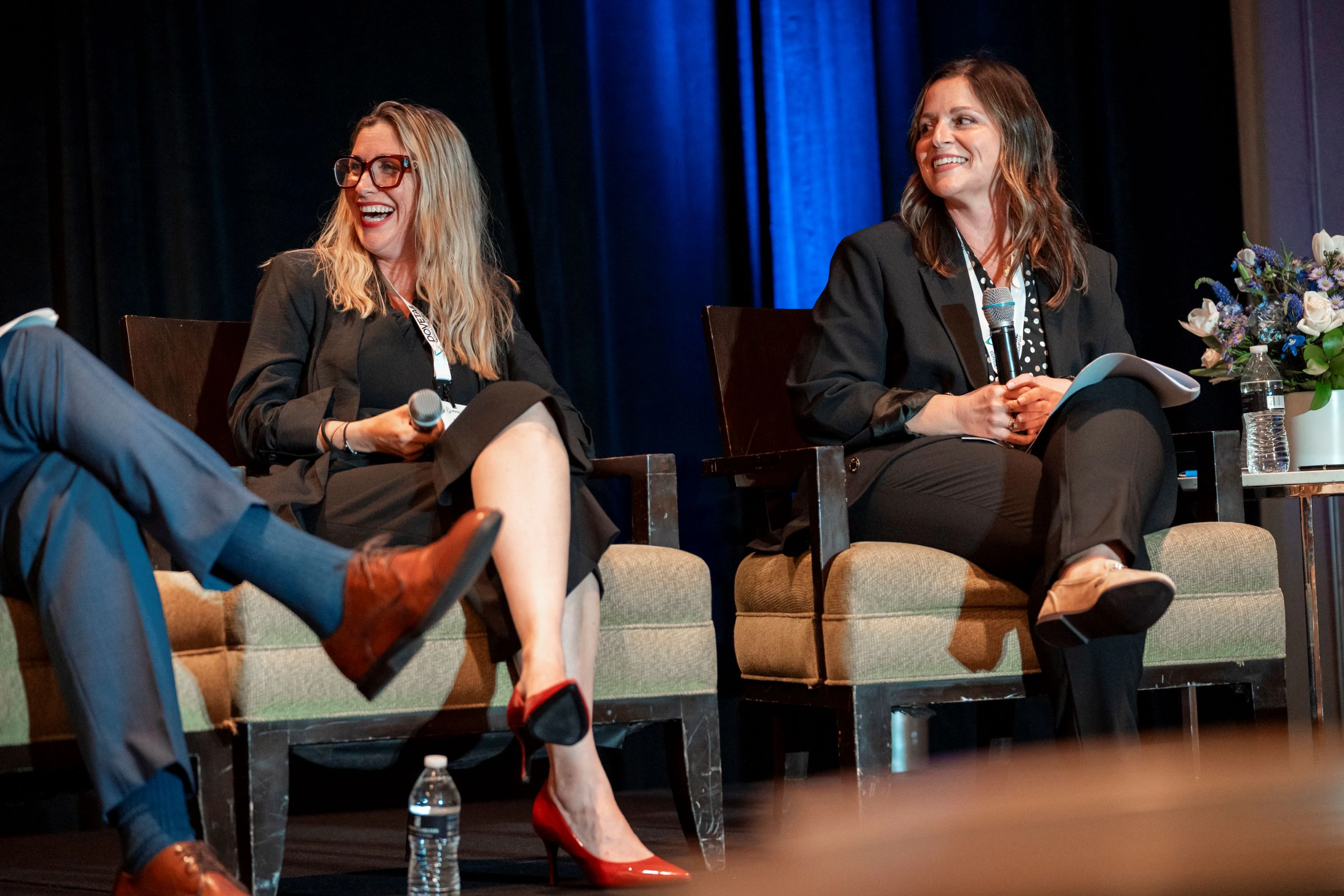 Two speakers on stage laugh at MDRP Summit