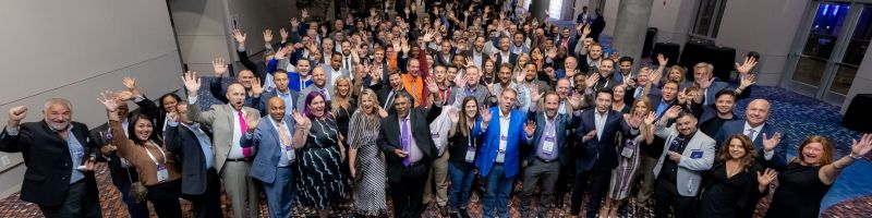 A photo of a crowd of people waving and smiling for the camera.
