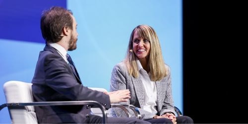 A photo of a man and a woman onstage participating in a keynote interview