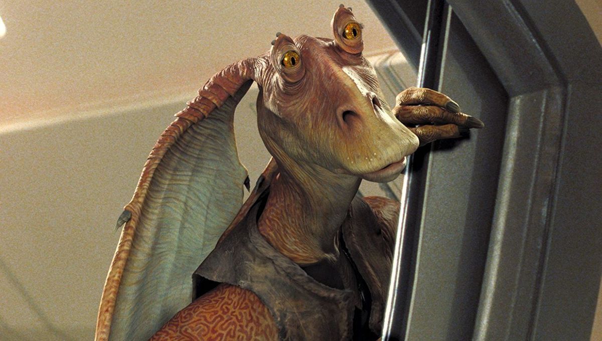 Jar Jar Binks stands in a door way with his hand holding the door open