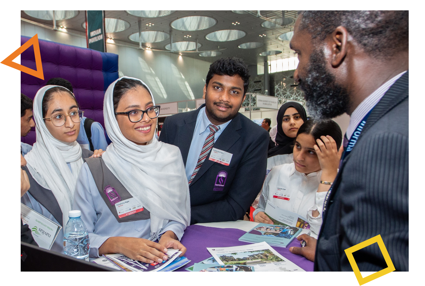 Group of high school students engaging with university reps at Najah Expo, exploring higher education opportunities.
