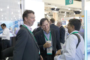 A group of attendees at BioProcess International standing in front of a globe.