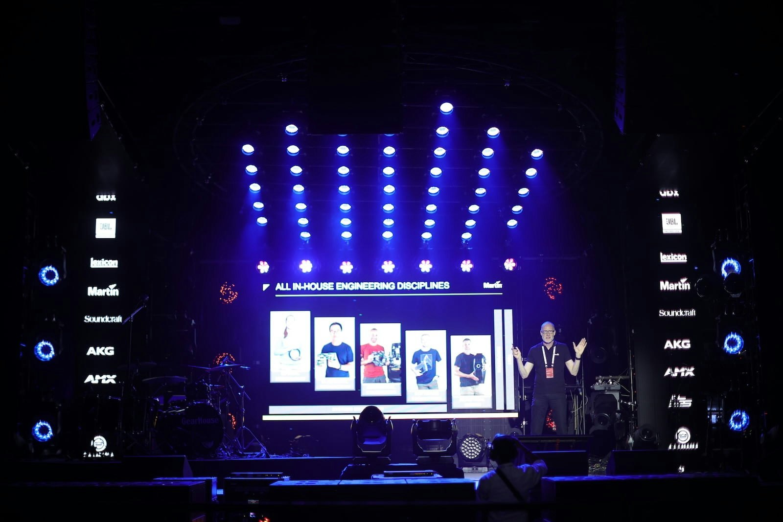 Wide view of live concert stage with purple and blue lighting at HARMAN Live Arena