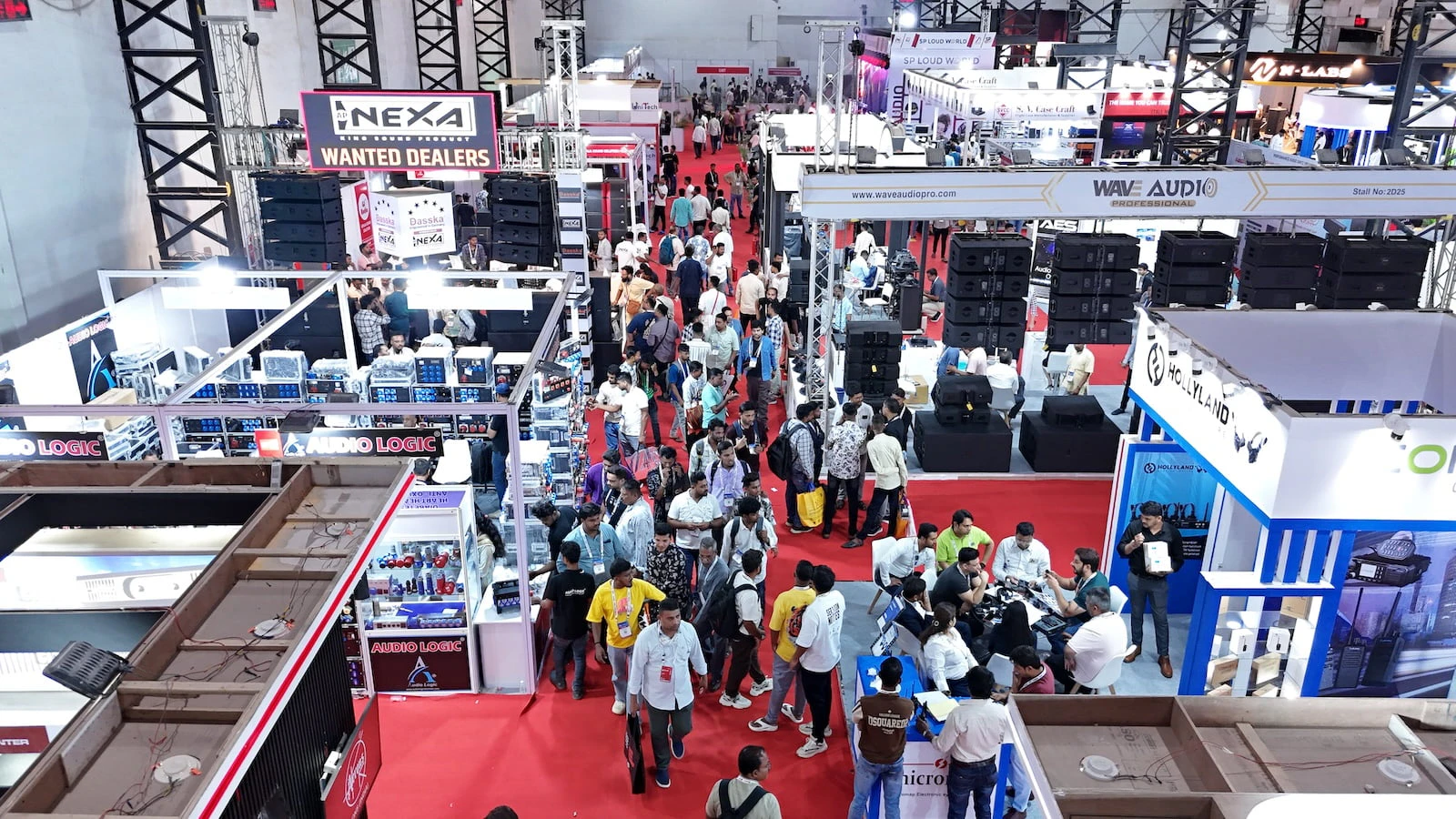Visitors exploring audio, lighting, and AV technology booths at PALM Expo exhibition hall