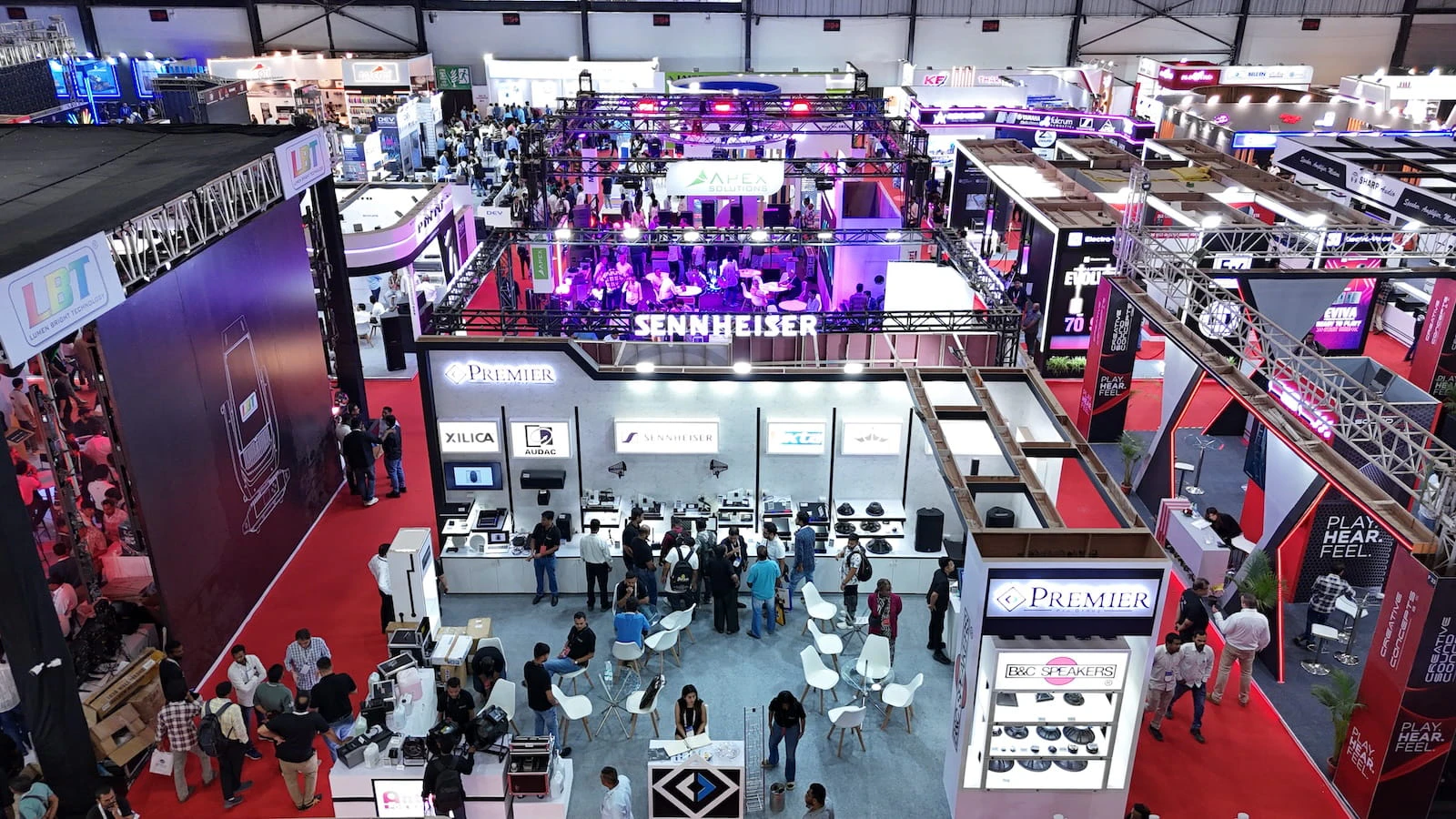 Visitors exploring audio, lighting, and AV technology booths at PALM Expo exhibition hall
