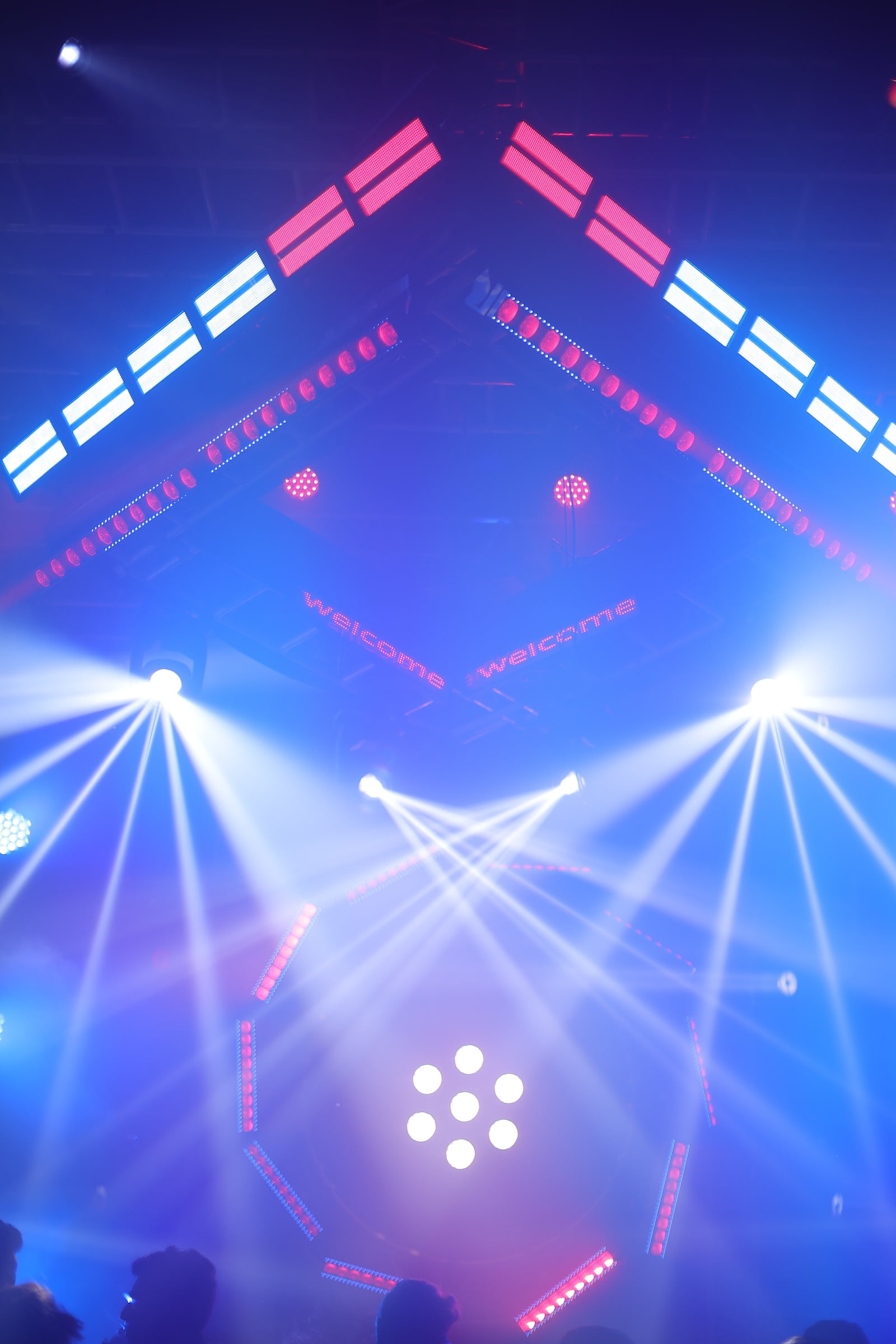 Dynamic multi-colored light beams illuminating stage at PALM Expo lighting showcase