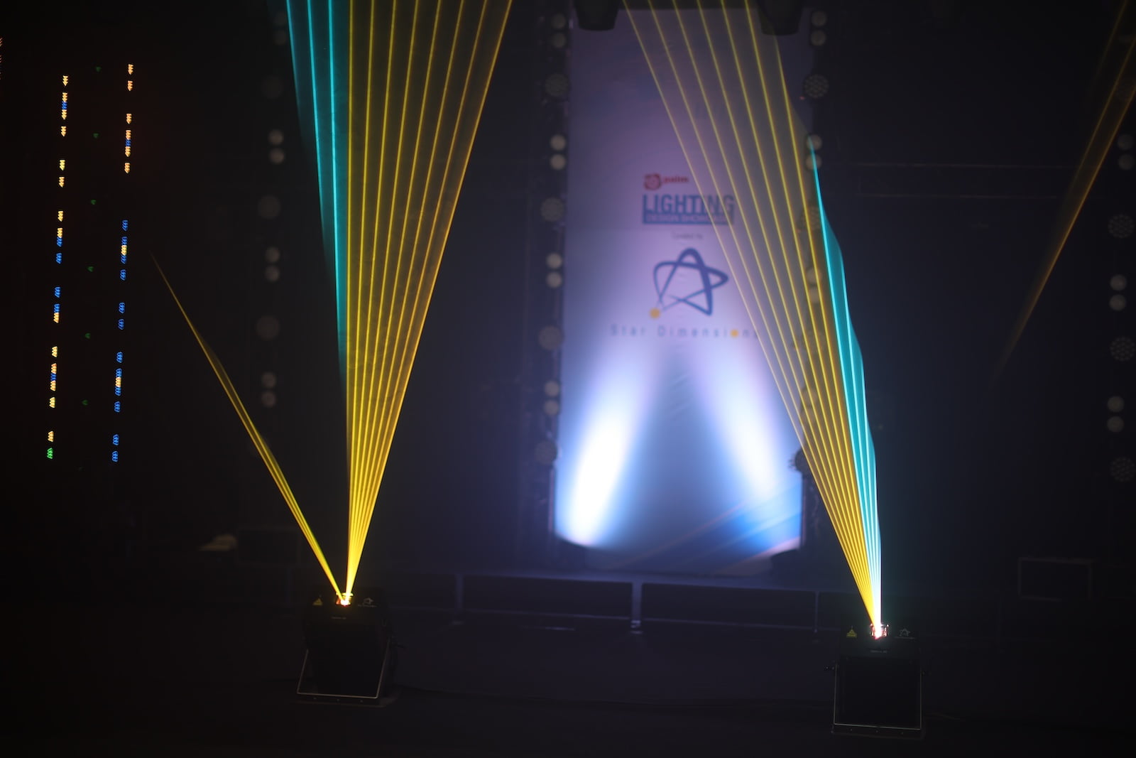 Vertical beams of yellow and blue stage lights during live lighting demonstration